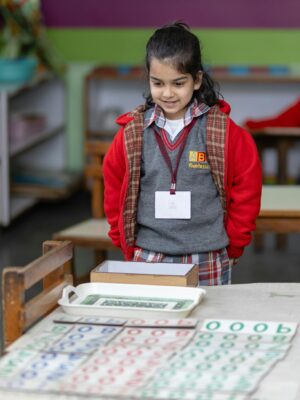 A child engaging with Montessori educational materials in a classroom setting.