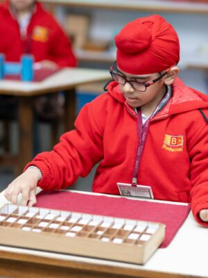 A child focused on educational activity in a Montessori classroom. Bright learning environment.